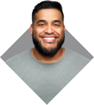 Un hombre con barba sonriente y con una camiseta gris